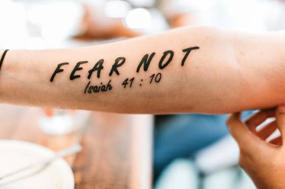 Citation « Fear not » sur l'avant-bras (tatouage lettrage)