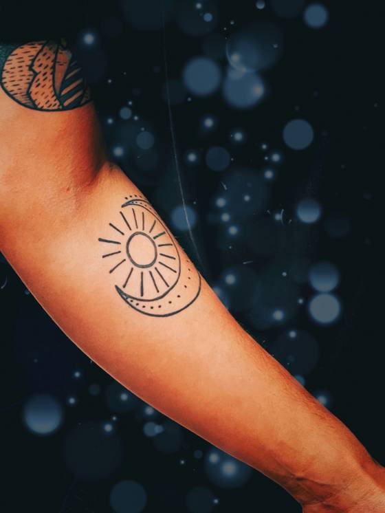 Soleil et lune minimalistes sur le bras (tatouage minimaliste)