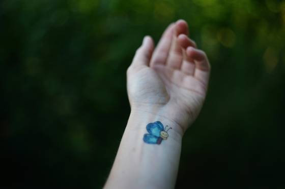 Papillon bleu sur le poignet (tatouage aquarelle)
