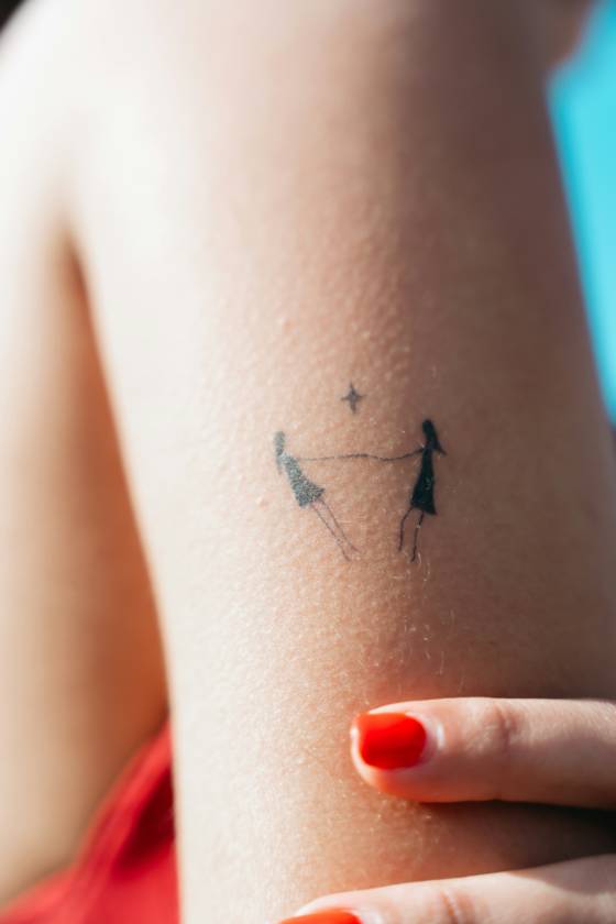 Deux silhouettes main dans la main (tatouage minimaliste)