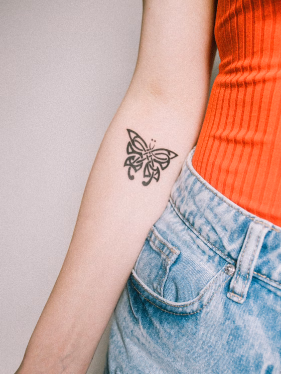 Papillon sur l'avant-bras (tatouage fine line)