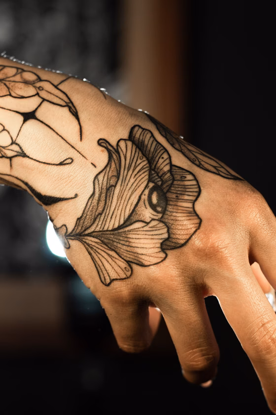 Fleur et toile d'araignée sur la main (tatouage illustratif)