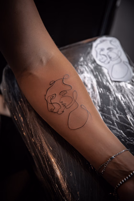 Line art minimaliste sur l'avant-bras (tatouage fine line)