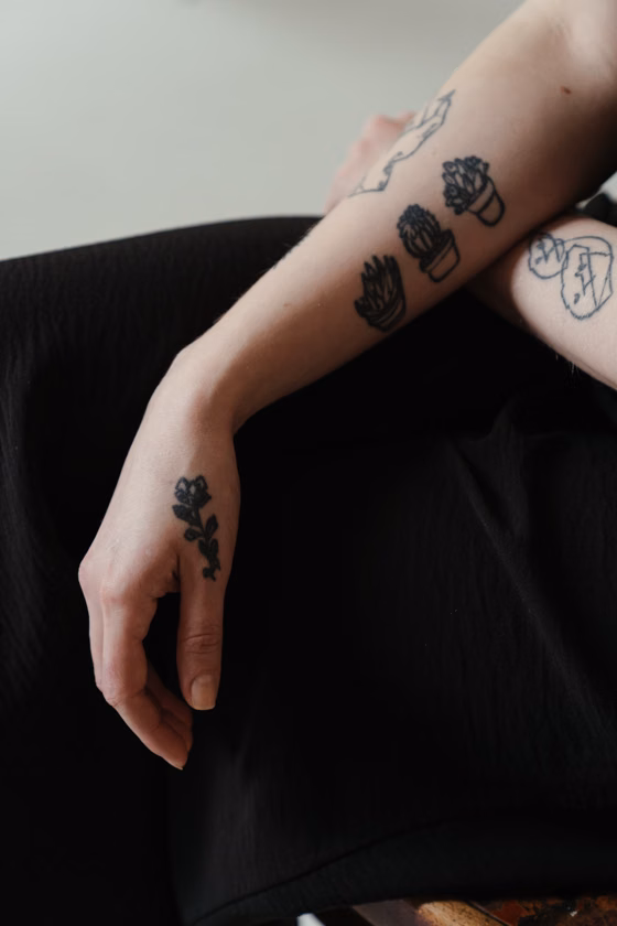 Petits motifs noirs sur le bras (tatouage blackwork)